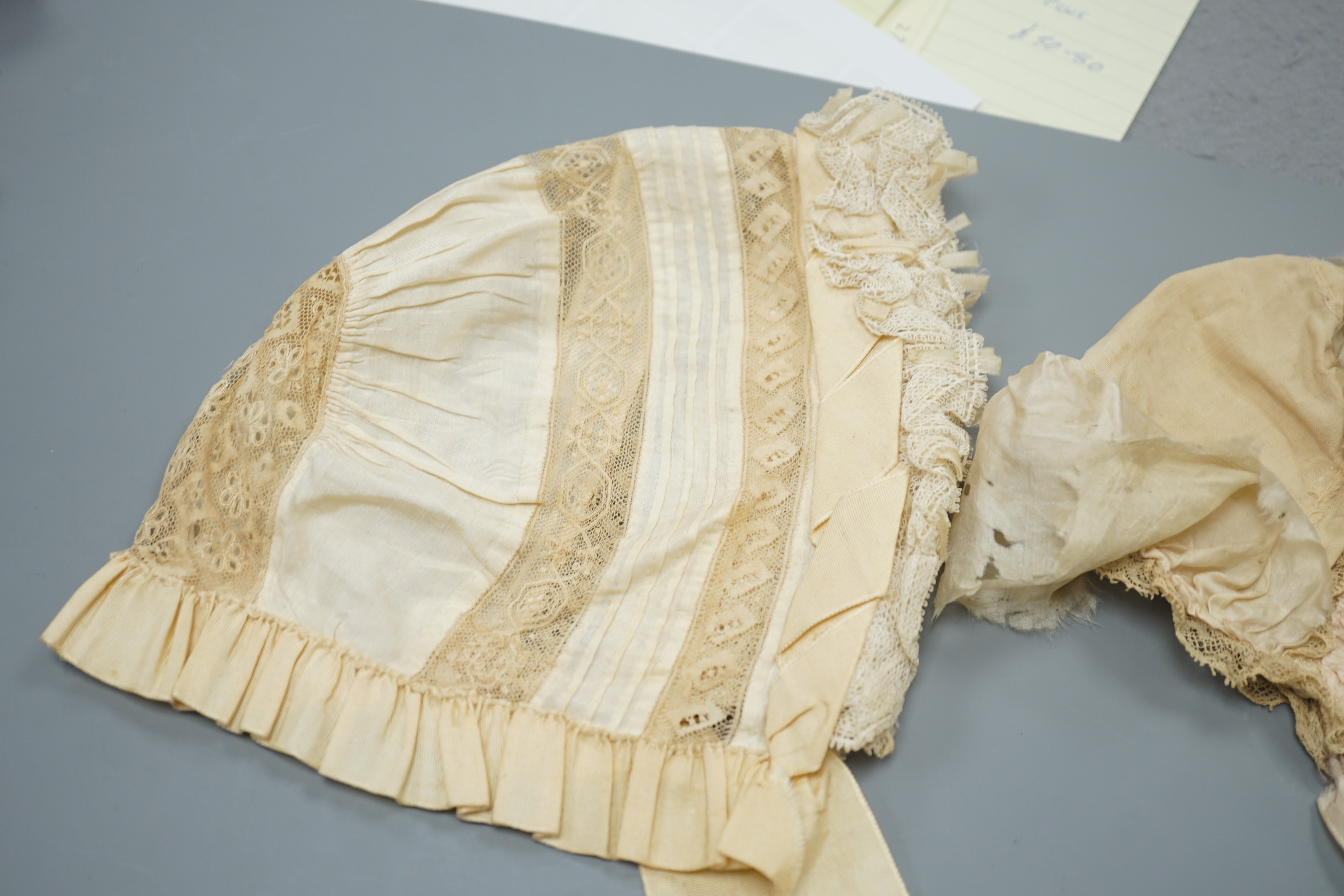 Three babies bonnets, two cream silk, one cotton